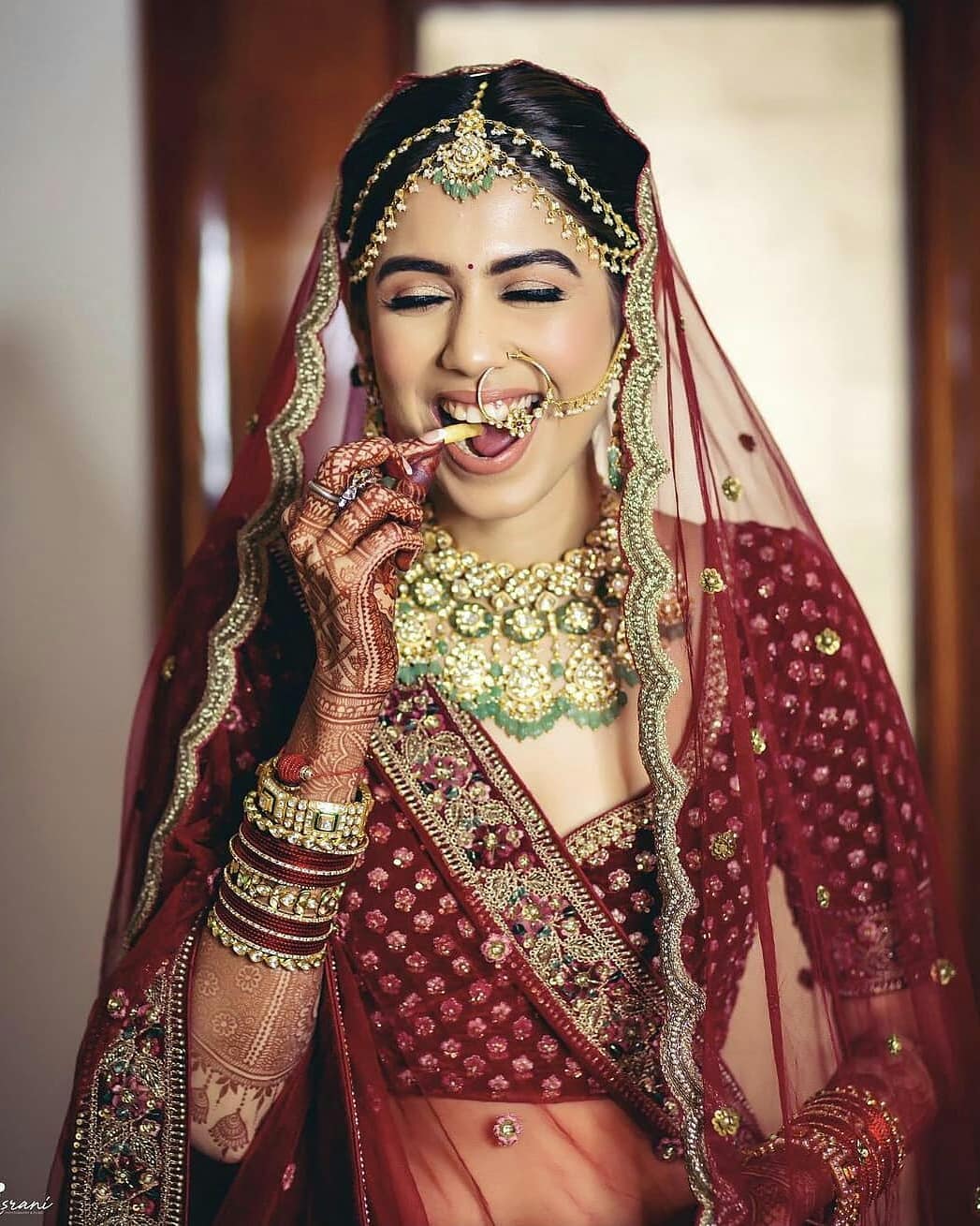 Beautiful portrait picture of a bride in amazing mehroon/ wine colour  lehenga and green jewellery and red chura… | Bride photography poses, Bride  photography, Bride