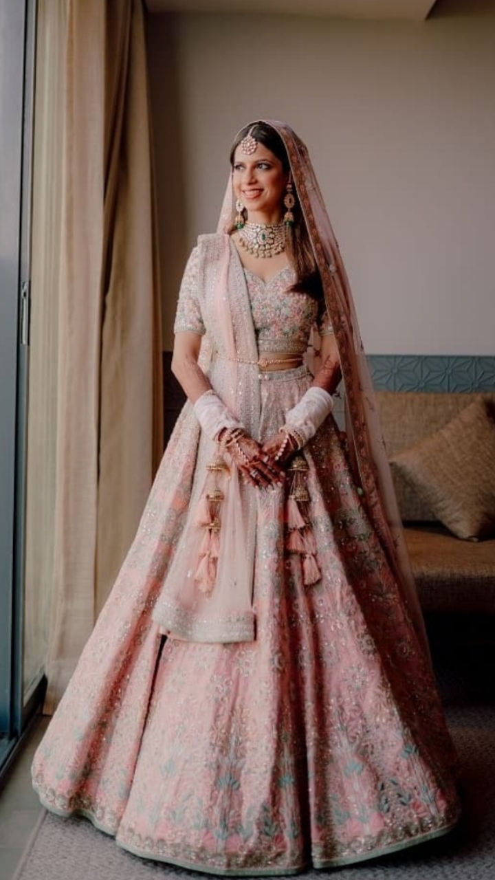 Photo of Pastel bridal lehenga in pink with green jewellery